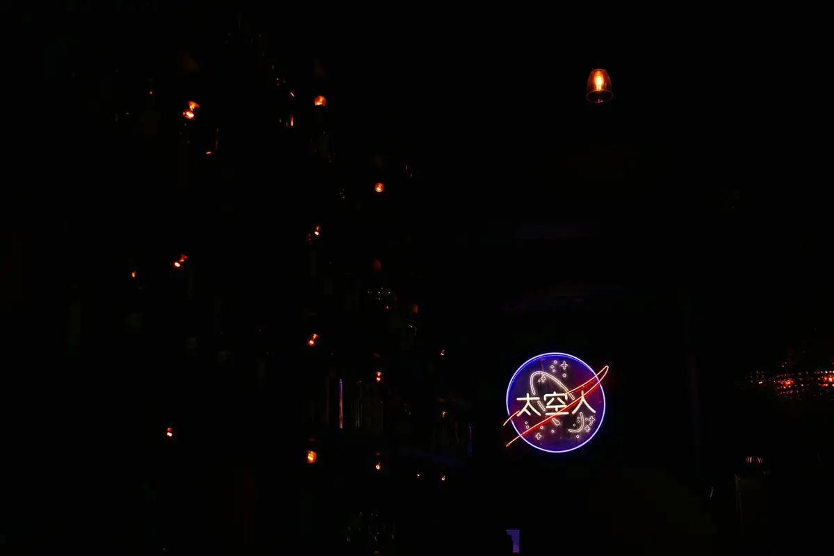 A neon Escape Rooms sign glowing in the dark